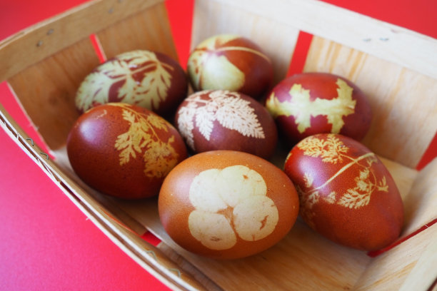 复活节篮子特写，里面有五颜六色的彩蛋。煮鸡蛋，有红色和棕色的壳，按照传统的食谱用洋葱皮染色。用植物叶子做成的花卉图案。图片下载