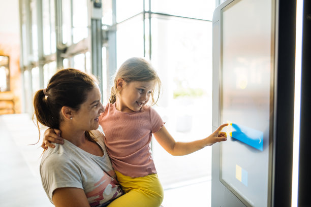母女俩在火车站使用触屏图片下载