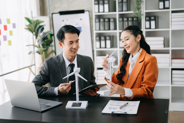 替代能源工程师指着太阳能电池板，与业务同事团队在办公室讨论未来的能源图片下载