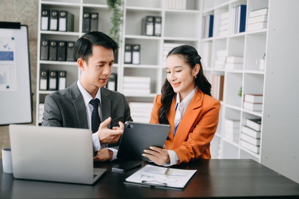 亚洲商务同事商务演示和解释，并使用笔记本电脑和平板电脑。团队合作，金融营销团队，而坐在家里的办公室。图片下载