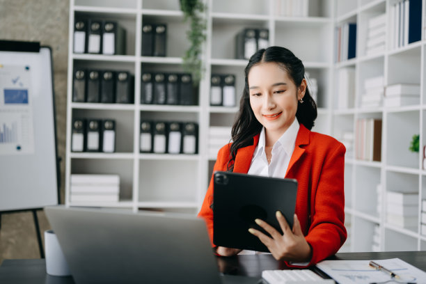 一位自由职业者正在用平板电脑和笔记本电脑工作，做会计分析报告，房地产投资数据，办公室财务图片下载