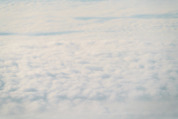 白天在云层上飞行的飞机的航拍照片图片下载