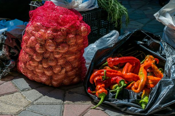 马其顿的一个蔬菜和水果摊贩在绿色市场上卖洋葱和辣椒图片下载