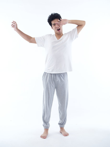 穿着白色背景睡衣昏昏欲睡的年轻人图片下载