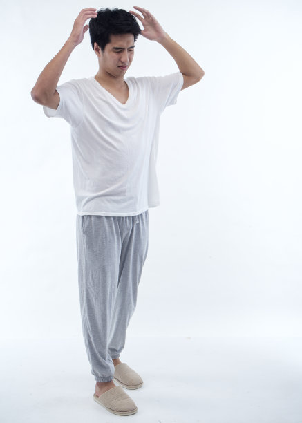 穿着白色背景睡衣昏昏欲睡的年轻人图片下载