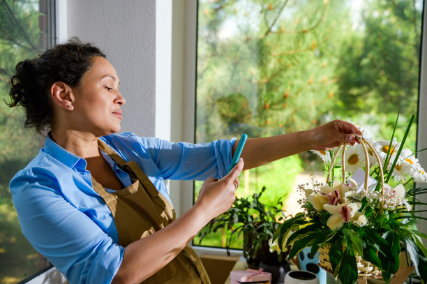 女花师为婚礼当天的柳条花篮拍摄插花，在花店处理订单图片下载