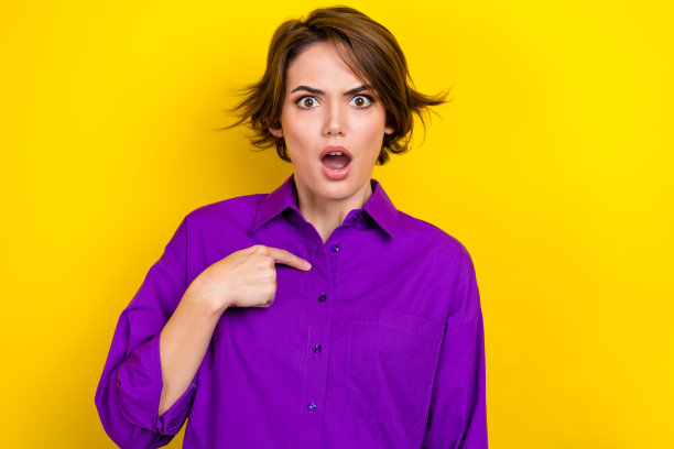 印象深刻的女孩张开嘴，用手指把自己孤立在黄色的背景上图片下载