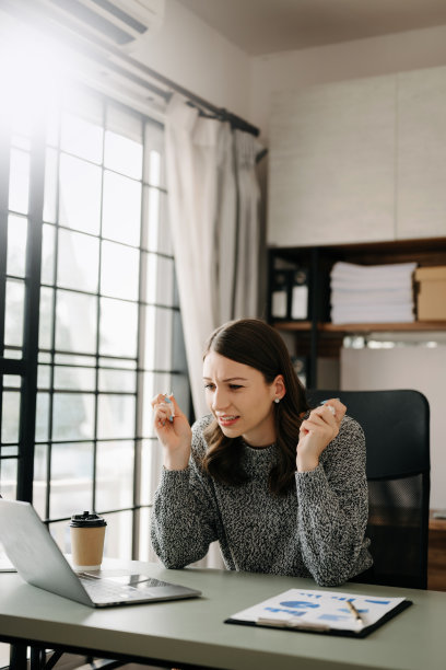 女性感到头痛。在办公室用笔记本电脑和平板电脑工作时过度劳累的女商人金融家。图片下载