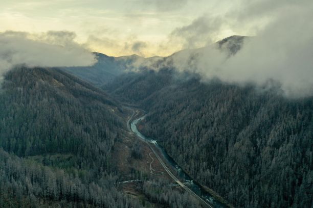 下面有一条河的山被云笼罩着图片下载