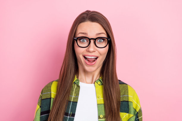 印象深刻的积极的漂亮女孩张开嘴不敢相信有牙齿的微笑孤立在粉红色的背景图片下载