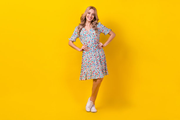 可爱的年轻女子的全身照片穿着时髦的花朵装饰裙子摆出时尚杂志孤立的黄色背景图片下载