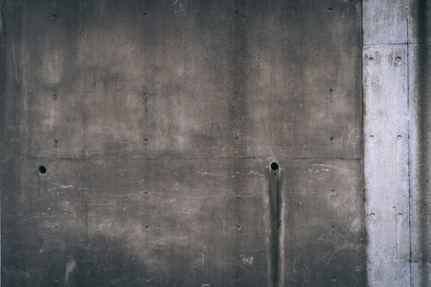 在东京市中心，可以透过一堵旧混凝土墙看到排水管。图片下载