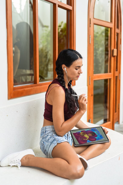 黑发乌克兰女艺术家和插图绘画，使用电子平板电脑和触控笔，通过使用触摸屏图片下载