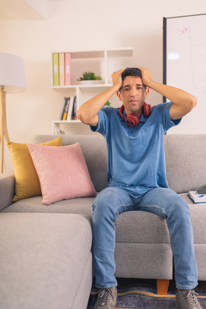 一个绝望的休闲商人坐在家里的垂直照片图片下载