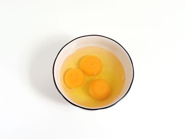 蛋黄在白色平坦表面的碗里的特写图像图片下载
