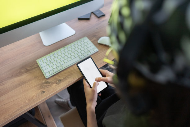学生坐在桌子上，在家里用笔记本电脑和智能手机做作业的特写照片。图片下载