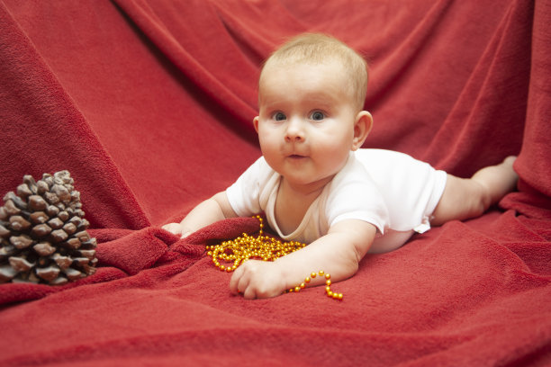 婴儿躺在红地毯上图片下载