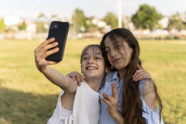 女孩们在绿色的田野里消磨时光。图片下载