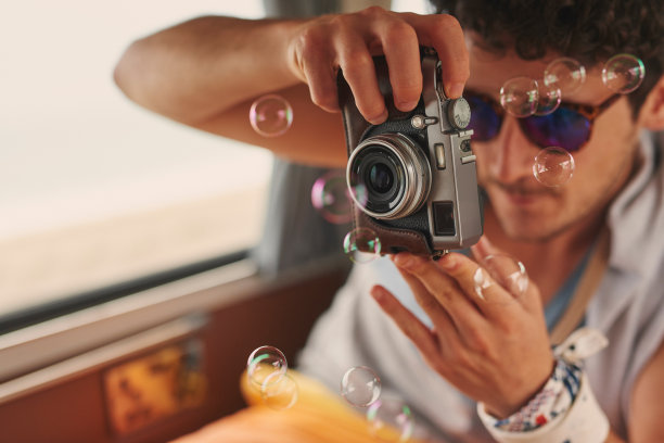 一个年轻人在他的货车里用相机进行公路旅行的照片图片下载