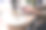 一杯咖啡放在咖啡馆的桌子上，背景是一个在笔记本电脑前工作的女孩的模糊的手。在线工作。特写镜头。有选择性的重点。图片下载