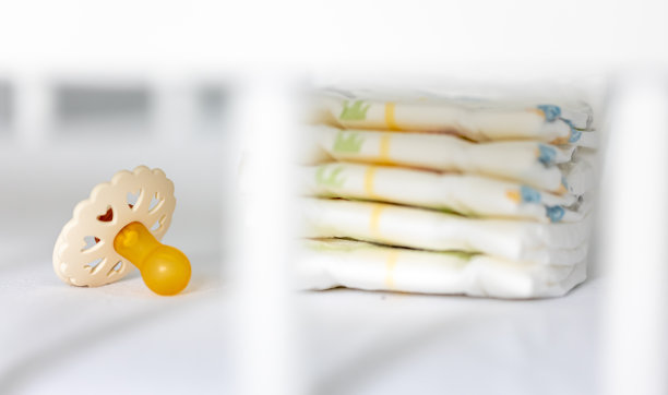 婴儿床里的婴儿奶嘴和尿布，特写。图片下载