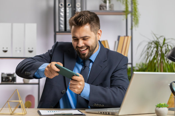 商人在智能手机上玩令人兴奋的移动应用程序庆祝赢得射击游戏图片下载