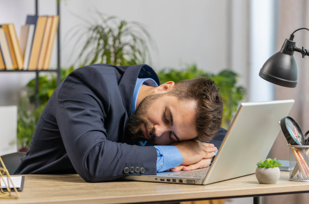 无聊困倦的高加索商人工人在笔记本电脑上工作，在家里办公室睡着了图片下载