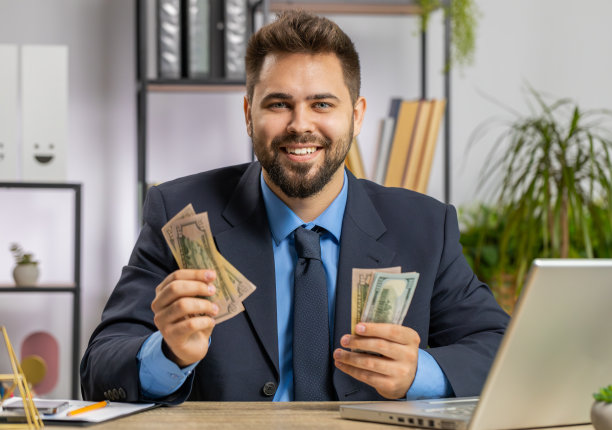 西装革履的富商在笔记本电脑上计算现金，计算收入利润图片下载