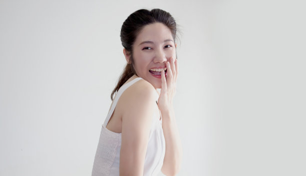 亚洲美女举起手触摸嘴唇，带着幸福和害羞的微笑图片下载