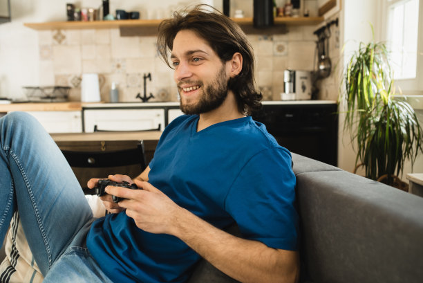 一个兴奋的年轻人在玩电子游戏图片下载