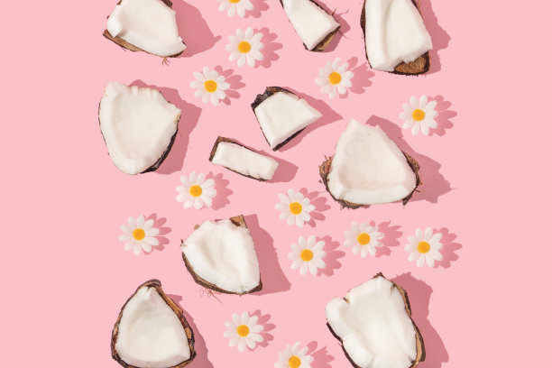 夏季创意图案与椰子片和白色花朵在粉彩背景。80年代或90年代复古美学时尚背景。热带水果夏天的想法。图片下载