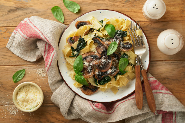 奶油阿尔弗雷多意大利面。意大利面，蘑菇，鸡肉，菠菜，罗勒和奶油酱在古老的乡村餐桌背景。传统的意大利菜。平的。本空间图片下载
