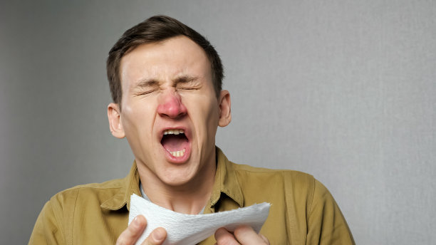 因对灰尘过敏而打喷嚏的红鼻子男子图片下载