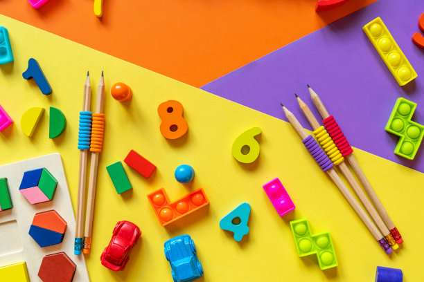 彩色纸上的木制儿童玩具。益智玩具积木，金字塔，铅笔，数字。幼儿园、学前班或日托所的玩具。文本的复制空间。俯视图图片下载