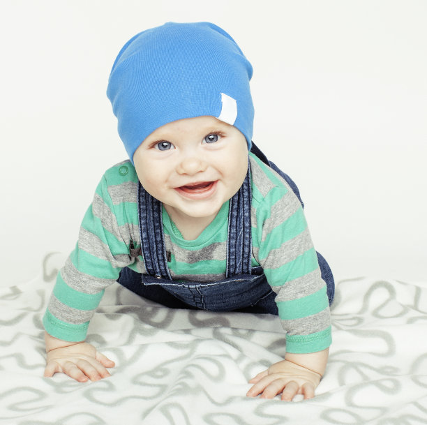 可爱的小婴儿蹒跚学步在地毯上孤立的近距离微笑可爱开朗图片下载