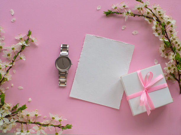 女性腕表粉红色的背景与樱花和复制空间图片下载