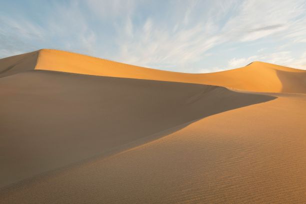 一望无际的金色沙滩，背景是深蓝色的天空图片下载