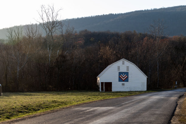 乡村谷仓沿着路边与山的背景图片下载