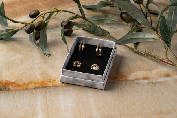 桌子上的金耳环和首饰盒特写图片下载