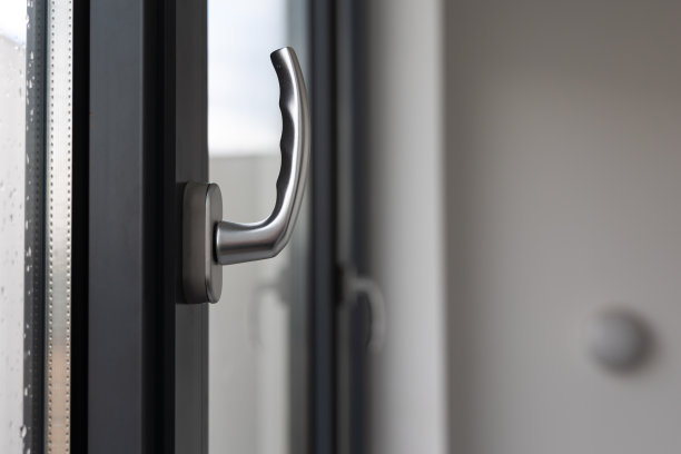 在公共建筑的大窗户上倾斜和转动窗户把手。图片下载