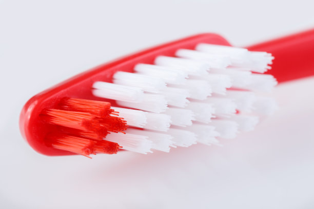 白色背景上的红色牙刷。注意个人卫生。图片下载