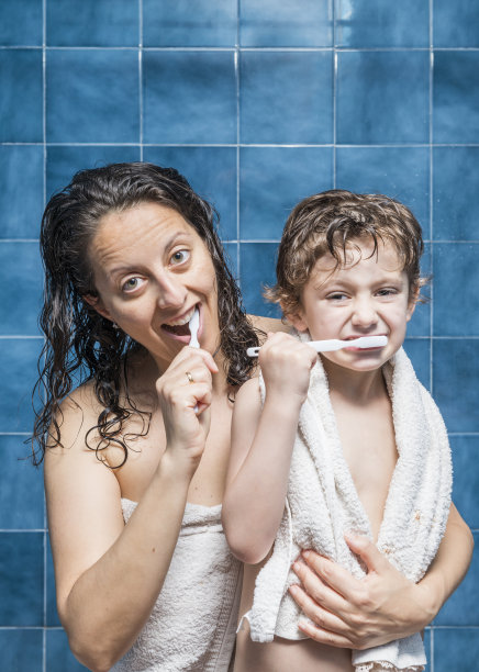 一个女人和一个孩子正在刷牙图片下载