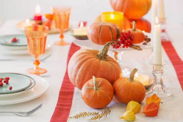秋天的餐桌上有燃烧的蜡烛和南瓜图片下载