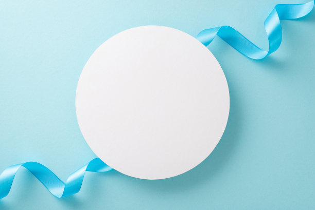 白色空圈的俯视图照片，在一个孤立的浅蓝色背景与复制空间的淡蓝色丝带图片下载