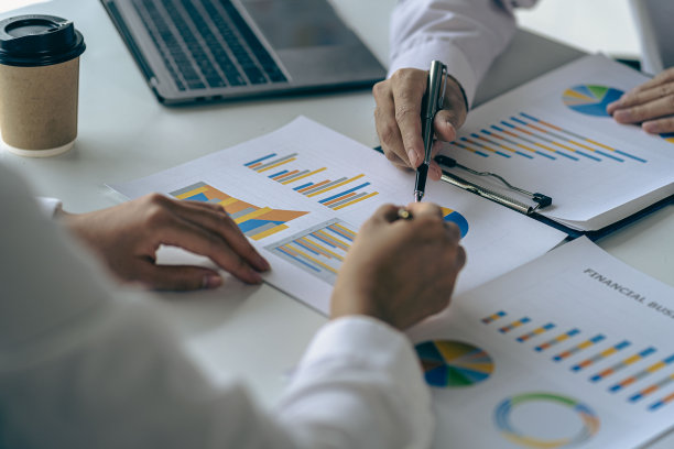 在公司会议讨论中分析财务图表文件上的业务财务报告，表现出成功的团队合作。商业会计概念特写图片图片下载