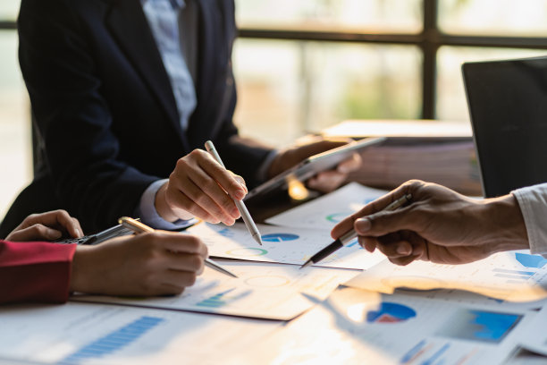 在公司会议讨论中分析财务图表文件上的业务财务报告，表现出成功的团队合作。商业会计概念特写图片图片下载