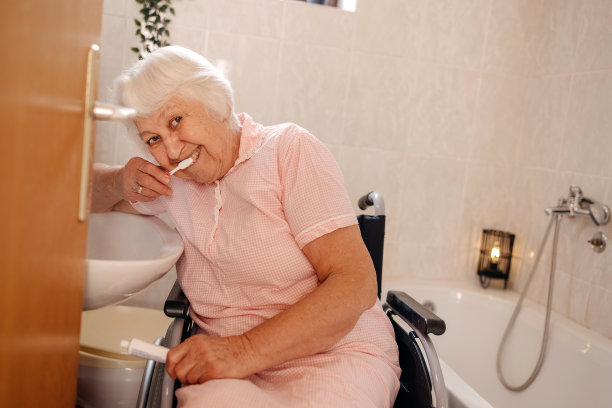 坐在轮椅上的老妇人在浴室洗牙图片下载