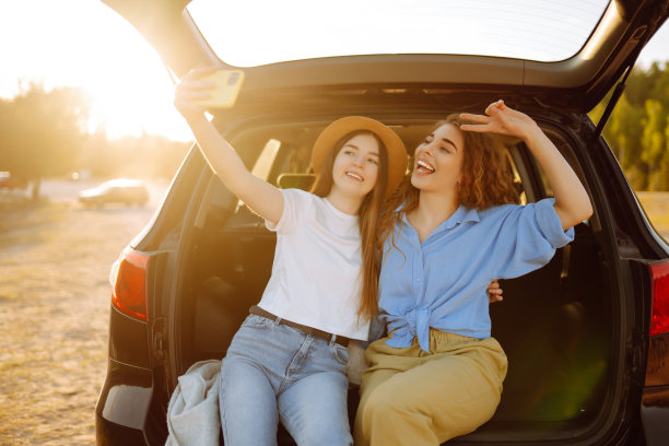 两名年轻女子在自驾游期间在车里自拍图片下载