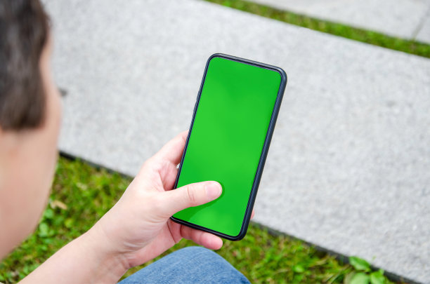女性手持智能手机。绿屏，复制空间，屏幕色度键。插入模板图片下载
