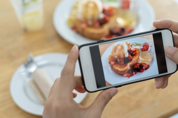 餐馆老板用智能手机拍下桌子上的食物，然后发布到网站上。在线外卖、订餐服务、网红、评论、社交媒体、分享、营销、兴趣。图片下载